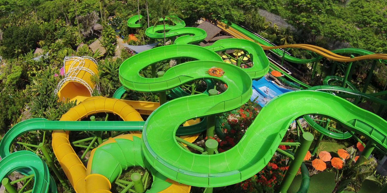 Riders twisting through the tree canopy on the Constrictor water slide at Waterbom Bali