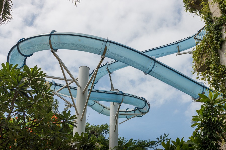 Rider speeding through the clear Pipeline slide above Waterbom Bali