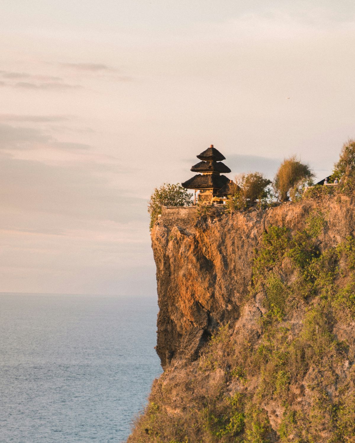 Uluwatu Temple perched on clifftop with Indian Ocean backdrop at sunset